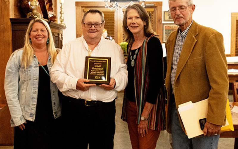 David Robinson (second from left) accepts a personal achievement award in recognition of his efforts in overcoming barriers to employment. Shown with Robinson are Emily Burch (left), employment specialist; and (at right) Lynne Manning, director of programs; and Dennis Myers, Vocational Resources services coordinator, all with IOI.