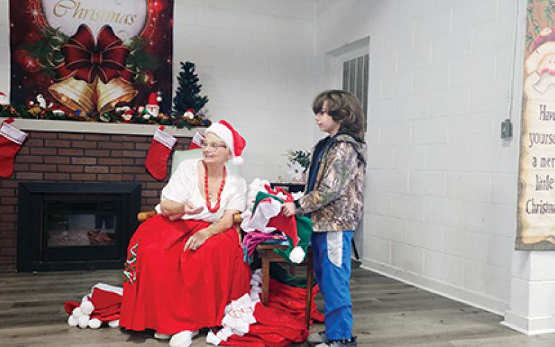 Mrs. Claus helps guide young ones to meeting Santa.