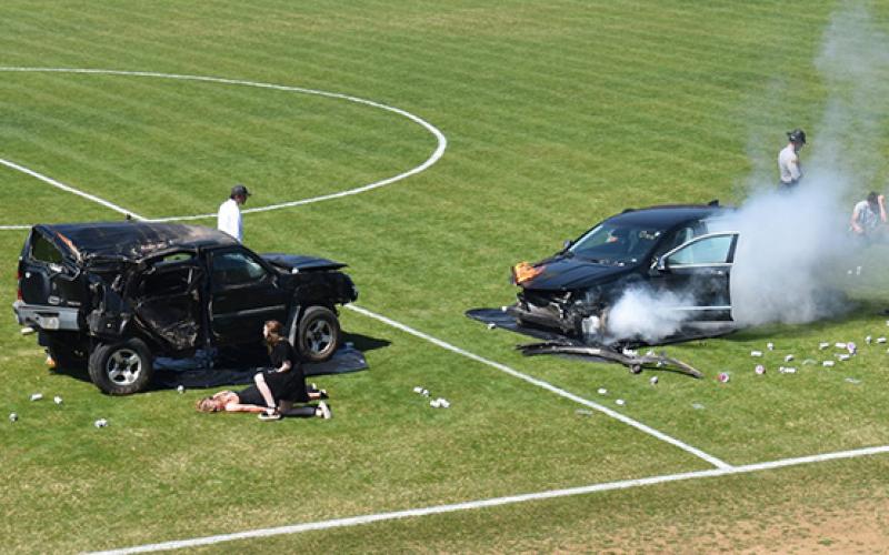 Two crashed vehicles sit on the Murphy High School football field on March 19 as part of a drunk-driving scenario aimed at getting teenagers to think about their choices.