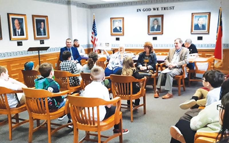 Photos by Anngee Quinones-Belian/Staff Correspondent  Nancy Helms of Ogreeta reads the book Beemer’s Adventures by author Jane Hembree of Murphy to a group of third-grade students from Peachtree Elementary School at Murphy City Hall on Thursday.