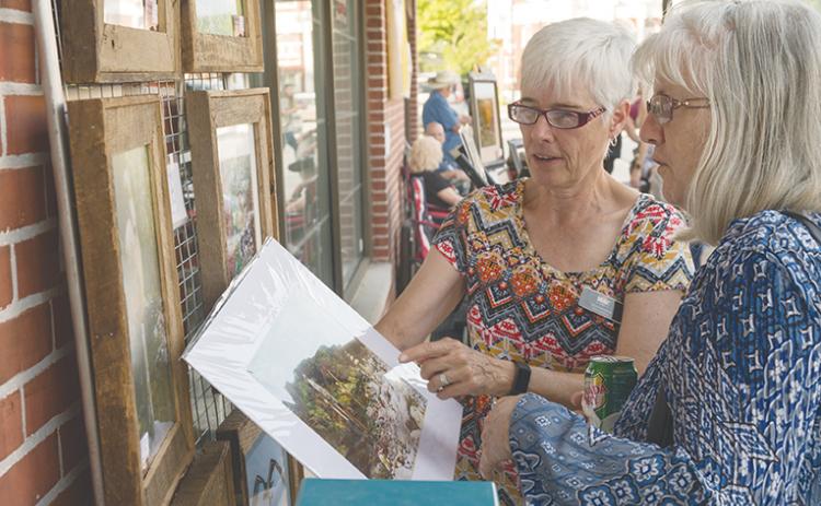 Kelly Kennon (left) explains to Sherry Barnes how she came upon a grouping of stacked water cairns on Fires Creek during last year’s Murphy Art Walk.
