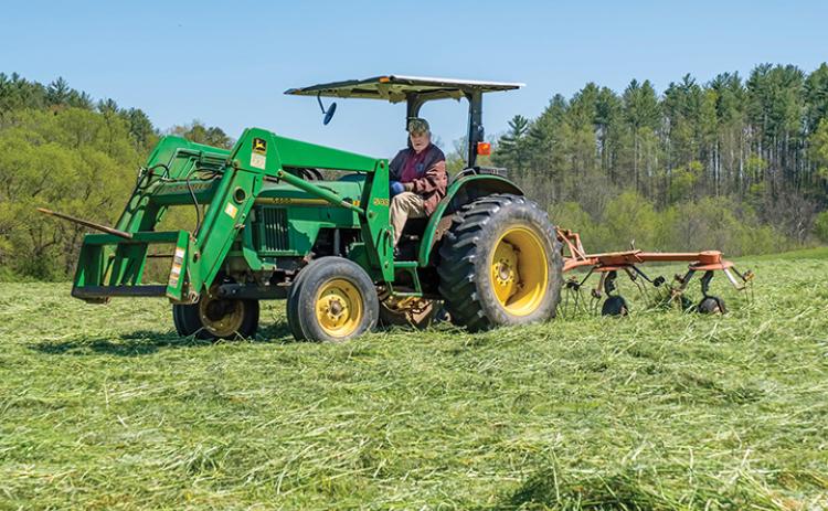 Ralph Myers, who will be 96 in September, still runs the John Deer tractor on his farm. He served in Europe during World War II as an anti-tank gunner. He was cutting hay, and will come back to roll it later, at John C. Campbell Folk School in Brasstown. Photo by Sam Jokich