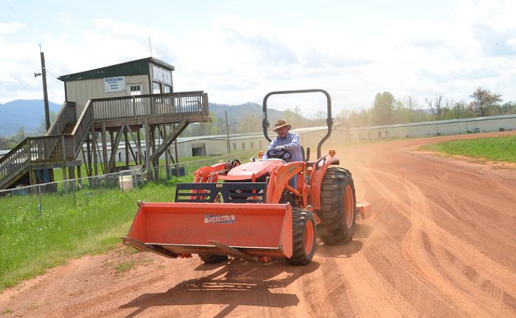 Commissioner Cal Stiles drives a tractor around the former go-kart track near the former Hillbilly Mall in Andrews to commemorate the final lap. Photo by Penny Ray