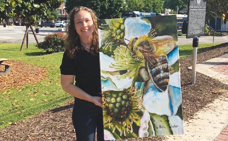 Holly Michelle Hargus shows off a painting that will be on display during the Cherokee County Arts Council’s July exhibit.