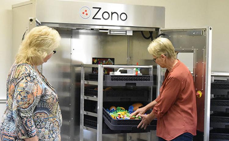 Health specialist Joyce Young and Head Start center director Sharon Palmer show how the Zono Cabinet works at Hilltop Head Start in Andrews. Photo by Samantha Sinclair
