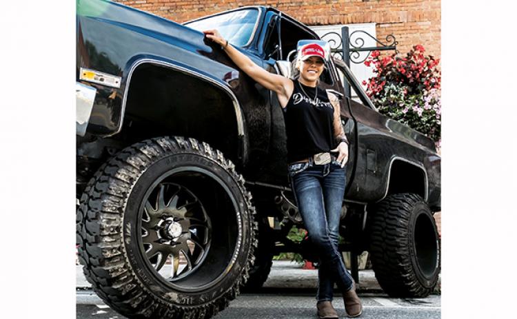 Peggy Noel poses with her large black Chevrolet truck. Photo by Sam Jokich