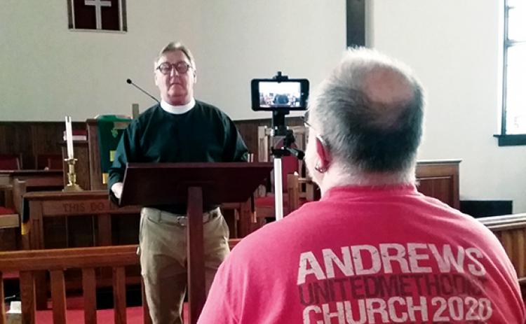 Jeanne Powell/For the Cherokee Scout Robby Morris records the Rev. Tom Jolly as he preaches his sermon in the sanctuary of Andrews United Methodist Church.