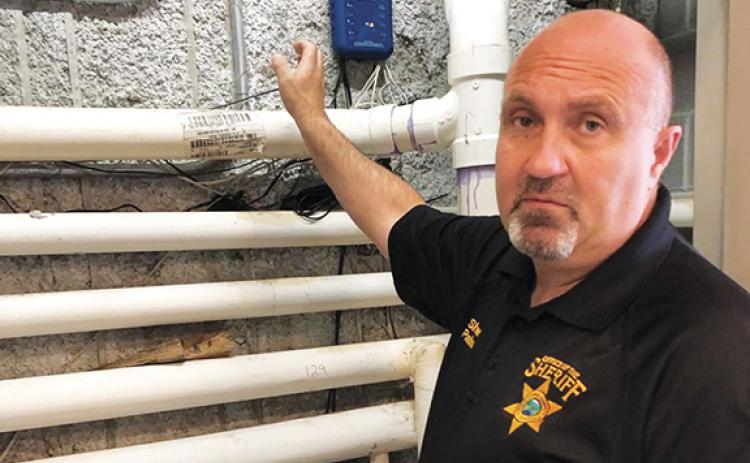 Cherokee County Sheriff Derrick Palmer explains the jail’s new plumbing system to foil inmates’ flooding.  Photo by Penny Ray