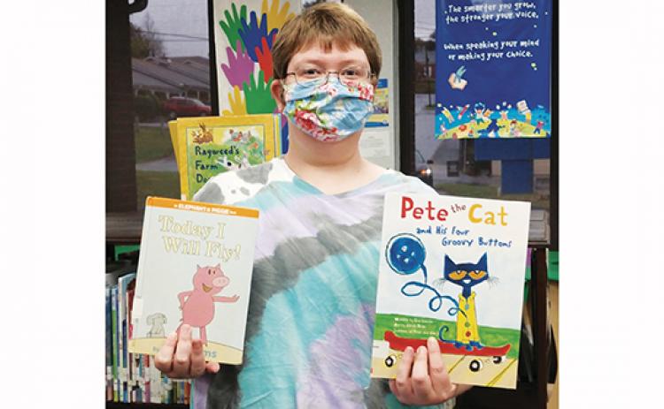 Youth Services Librarian Bridget Wilson holds books featuring Piggie and Pete the Cat, the two candidates in the Kids’ Book Character Election at local libraries.