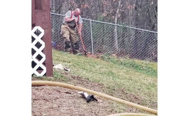 Jason Berrong from the Ranger Volunteer Fire Department buries a puppy that died in a residential fire on Old Murphy Road on March 17.