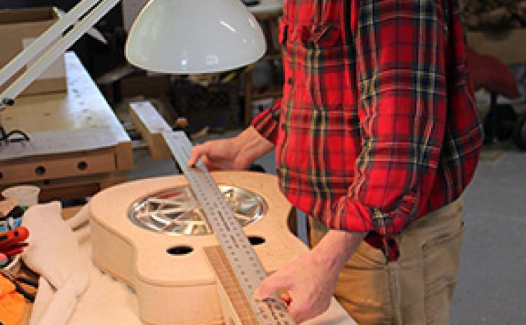 Stacy Van Buskirk/svanbuskirk@cherokeescout.com Mike Conner of Murphy tests the fit of the spider resonator cone in his handmade Dobro. It’s important that the parts fit snugly, not too tight, and the alignment is just right.