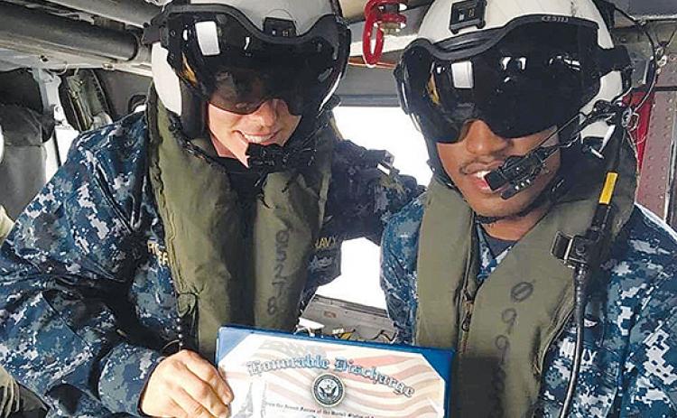 Murphy High School graduate Greg Lloyd does his re-enlistment in a helicopter over Tokyo. “You are discharged, then sign a new contract,” the Navy Blue Angel said.