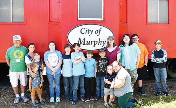 Photos by Bill Belian/Contributing Photographer  President Thomas Urso of the Valley River Model Railroad Club (far left) stands with students from Hidden Mountain Brilliance on May 17 at the L&N Depot in Murphy.