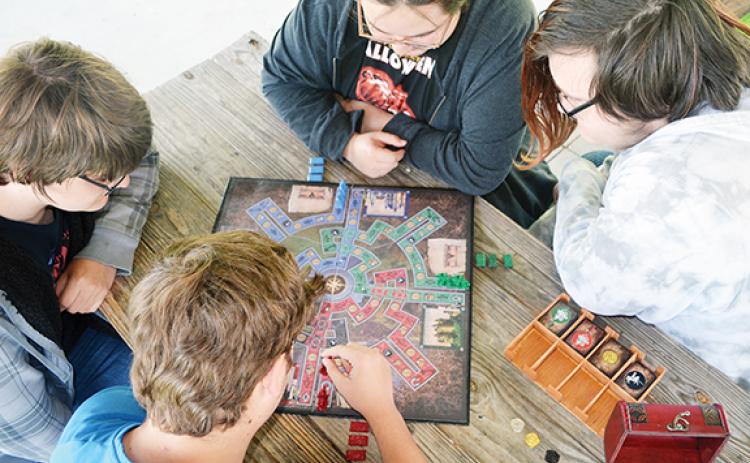 Abigail Hickman/Staff Correspondent Tom Spencer watches students Mylan Dockery, Carter Swafford, Manuel Rabon and Jacob Phillips play his invented board game, Castle Odyssey.