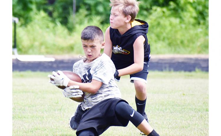 Justin Fitzgerald/sports@cherokeescout.com A total of 47 kids from age 7 through rising ninth-graders attended Murphy’s youth football camp from May 31 until Friday. Above, Wyatt Coleman steps in front of Brady Watson to break up a pass.