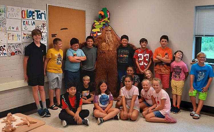 Bigfoot (otherwise known as local artist Mike LaLone) poses with students at Andrews High School on July 19.