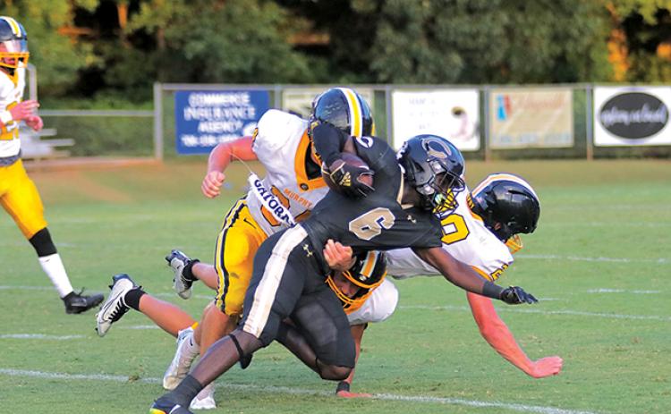 Murphy’s Ty Laney tries to bring down Commerce’s Jaiden Daniels during the Bulldogs’ 15-14 win over the Tigers on Friday night.
