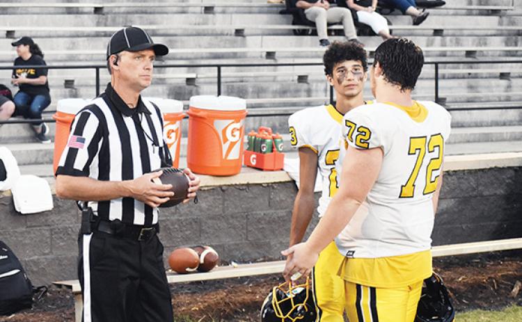 Justin Fitzgerald/sports@cherokeescout.com An official chats with Murphy captains Jeremiah Dickey (72) and Cameron Grooms (23) before the Bulldogs’ game against South Pittsburg, Tenn., on Friday night.