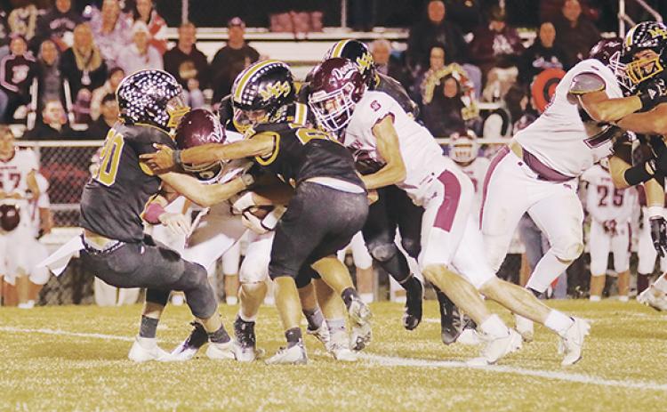 Dave Guffey/Contributing Photographer Murphy’s John Ledford (20) and Jonah Hedden (25) lead a group of Bulldogs trying to bring down the Swain County ball carrier during Murphy’s 20-14 win over the Maroon Devils on Friday night.