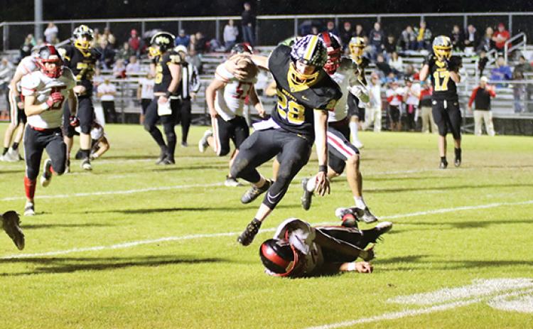Dave Guffey/Contributing Photographer A Murphy offensive football player plows through the Mountain Island Charter defense during the Bulldogs’ 38-34 win in the second round of the state 1A playoffs Thursday night, as the game was moved up a day due to the weather forecast.