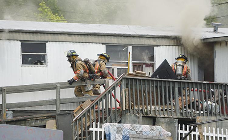 hotos by Randy Foster/editor@cherokeescout.com   Above: Murphy firefighters approach the entrance of a burning home near the intersection of Texana Road and Joe Brown Highway on Monday. 