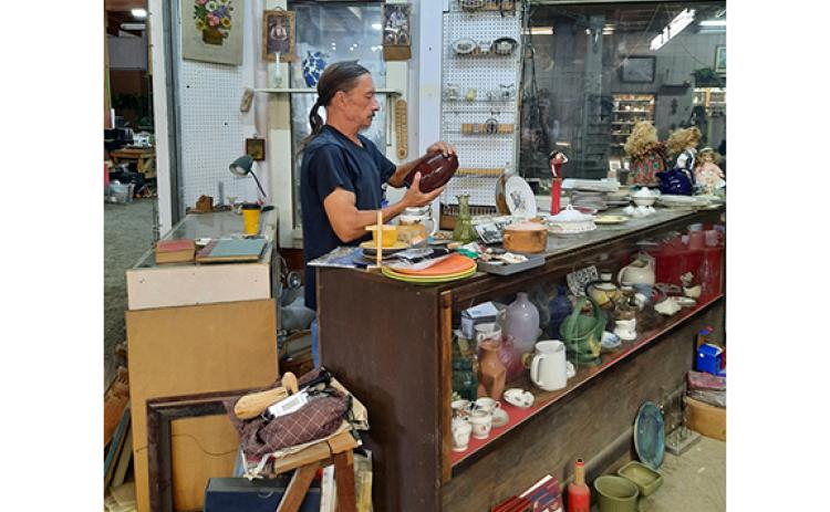 Photos by Anngee Quinones-Belian/Staff Correspondent  “Ponytail Mike” Asherbranner loved the flea market business and was good at finding items others could not. Last year, he was found examining an object in one of his shops at Decker’s Flea Market.