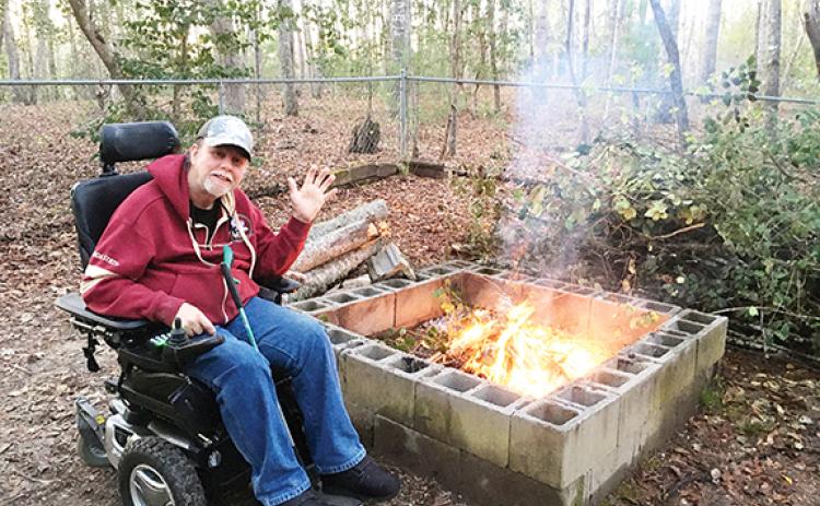 Photos by Becky Geyer/Contributing Writer Veteran Steve Geyer waves by his fire pit. He won a free roof for his house as a part of the Beacon of Hope Initiative, which provides a new roof for 10 veterans each year.