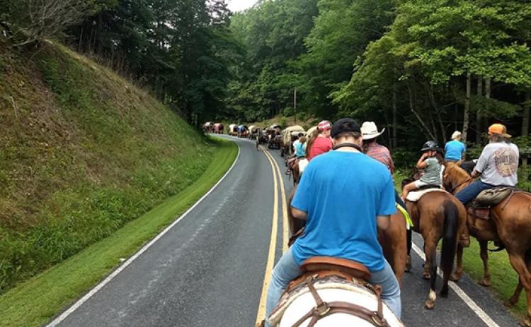 The Western North Carolina Wagon Train rounds a curve in Mineral Bluff, Ga., during this year’s summer ride.