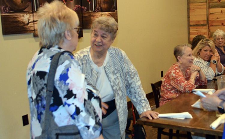 Abigail Blythe Batton/Staff Correspondent Karen Borchers, executive director of the United Way, greets a guest during her retirement dinner at Legend’s Steakhouse in Murphy on Thursday night.