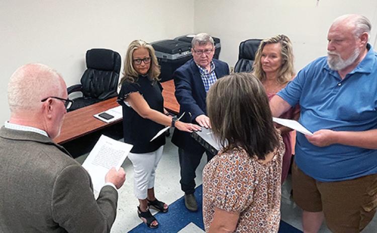 Photos by Randy Foster/editor@cherokeescout.com Clerk of Court Roger Gibson (left) administers the oath of office to board members as Director of Elections Leighsa Jones (foreground) holds a Bible at the Cherokee County Board of Elections office in downtown Murphy on July 18. Taking the oath are (from left) Shelley Debty, Craig Allen, Sandy Solesbee and Charles Hoesch.