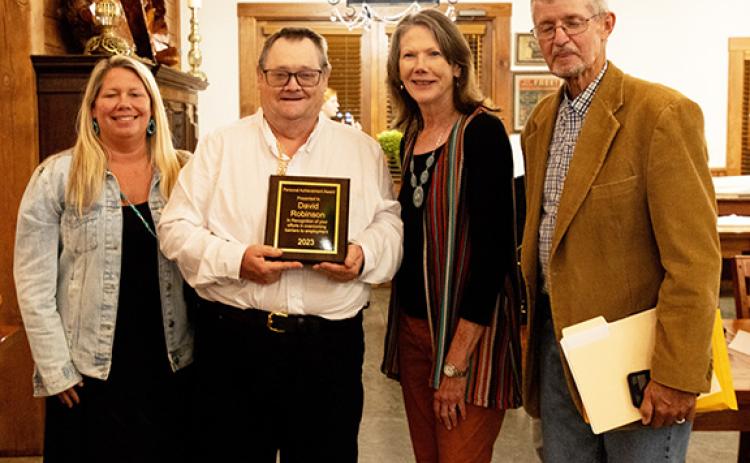 David Robinson (second from left) accepts a personal achievement award in recognition of his efforts in overcoming barriers to employment. Shown with Robinson are Emily Burch (left), employment specialist; and (at right) Lynne Manning, director of programs; and Dennis Myers, Vocational Resources services coordinator, all with IOI.