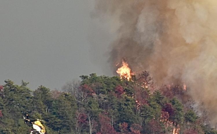 Fire as seen from Pisgah Road. Notice the helicopter approaching from the lower right preparing to drop water on the blaze. 