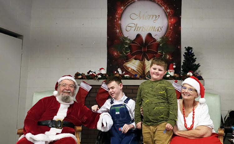 Photos by Nicole Wright/Staff Correspondent Conner and RayLynn Waldroup visit with Santa and Mrs. Claus at Cruise Night for the Kids’ final Christmas party. Over the last 16 years, thousands of gifts have been handed out.