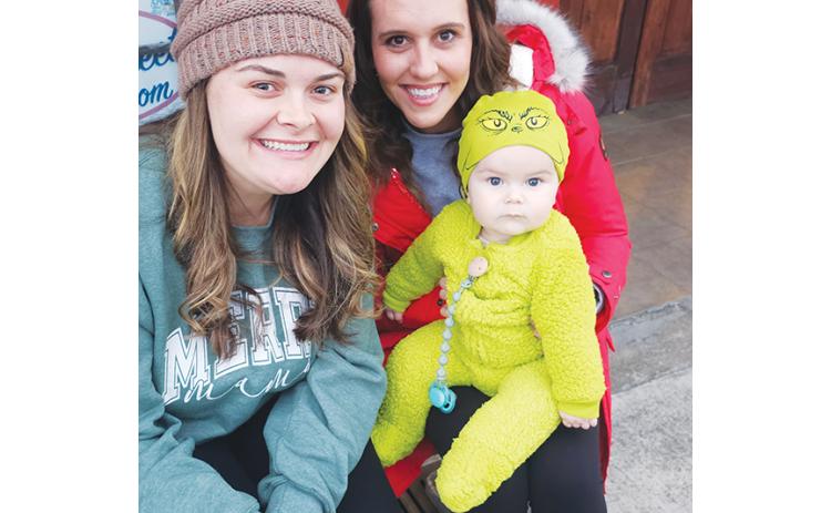 Nicole Wright/Staff  Correspondent Mackenzie, Hailey and Tate Rogers as the cutest baby Grinch wait with anticipation for the Andrews Christmas Parade to start Saturday evening downtown. The parade was delayed for a week, but the good-size crowd didn’t seem bothered in the least.