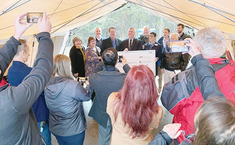 Randy Foster/editor@cherokeescout.com Attendees record the moment as local and state dignitaries pose with a symbolic check on Friday during a groundbreaking ceremony for Valley River Apartments, a 56-unit, low-cost apartment complex that will be built behind Walmart in Murphy.