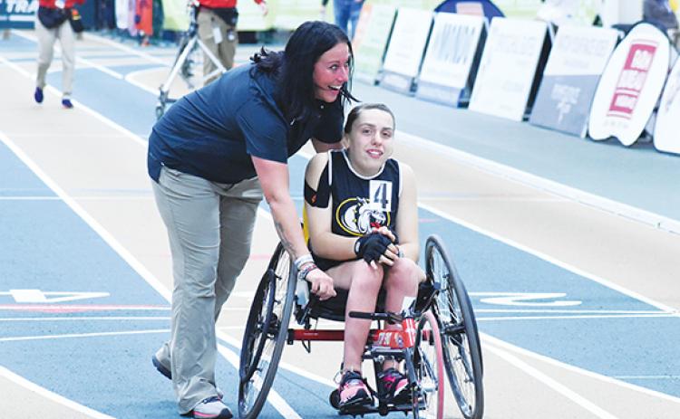 Photos by Kevin Hensley/The Graham Star Jordan Oliver (right) and Kristie Oliver (left) embrace after Jordan wins the state championship in the wheelchair 55-meter dash and sets her a new personal record Saturday at the N.C. High School Athletic Association Indoor Track State Championship.
