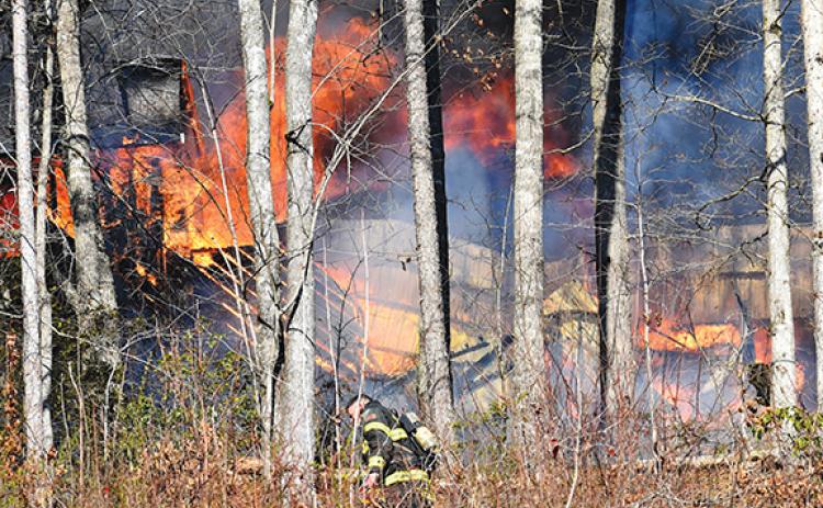 Randy Foster/editor@cherokeescout.com A firefighter approaches a burning home owned by the Burns family at 41 Ramsey Estates in Murphy on Feb. 21.