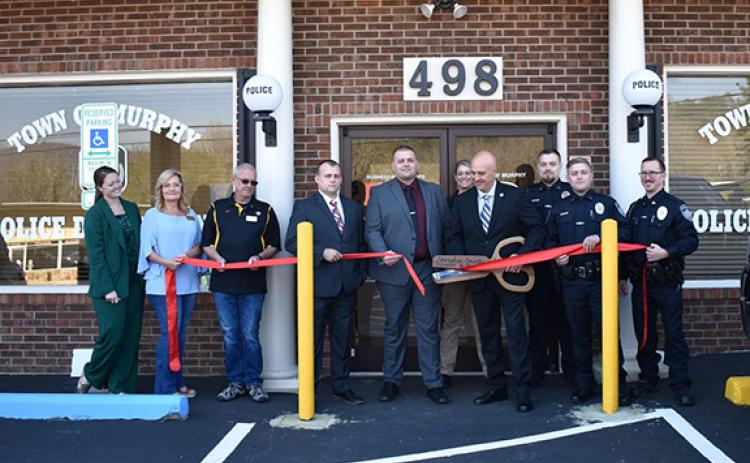 Bill Belian/Contributing Photographer  The Cherokee County Chamber of Commerce held a ribbon-cutting ceremony for the new Murphy Police Department building Thursday at 498 Hill St. From left are Victoria Ivie (Cherokee County Chamber of Commerce executive director); town council members Cindy Chastain and Barry McClure; Investigator Jason Murphy, Assistant Chief Ryan Cunningham, BLET student Sara Taylor, Cpl. Hunter Sanders, Patrol Officer Parker Southard and Sgt. Adam May, with Chief Tim Lominac in the cen