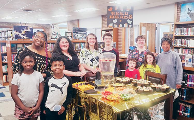 Nicole Wright/Staff Correspondent In front (from left) Thursday at the Andrews Public Library are Natalie George and Eli George. In back are Kristen George, Sarah Hardman; Shawn Hardman, Nathaniel Bressler, youth services librarian Bridget Wilson, Elliot Young, Autumn Young and Ann Miller Woodford, daughter of the late Purel Miller.