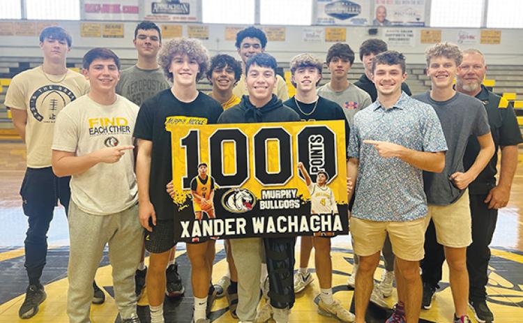 J.R. Carroll/Staff Correspondent Xander Wachacha celebrates with teammates during a ceremony Thursday at Murphy High School after scoring his 1,000th career point in a game against Bishop McGuiness on March 5. Wachacha started his high school basketball career in Robbinsville, but transferred to Murphy for his senior season. He is the second Bulldog this season to reach this milestone following Dominick Rummler
