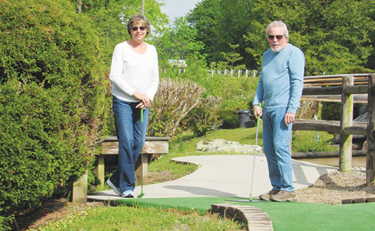  Chris Faries/Contributing Photographer Patty (left) and John Singer participate in the mini-golf tournament during last year’s Senior Games.