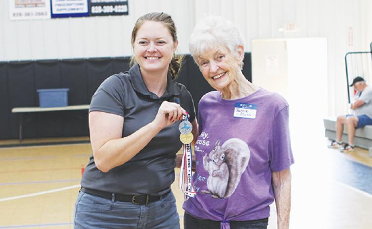 Cannon Crompton/sports@cherokeescout.com First-time Senior Games athlete Bonnie Motes, 88, of Murphy, celebrates her two medals in softball and football throws Saturday with Cherokee County Chamber of Commerce Executive Director Victoria Ivie.