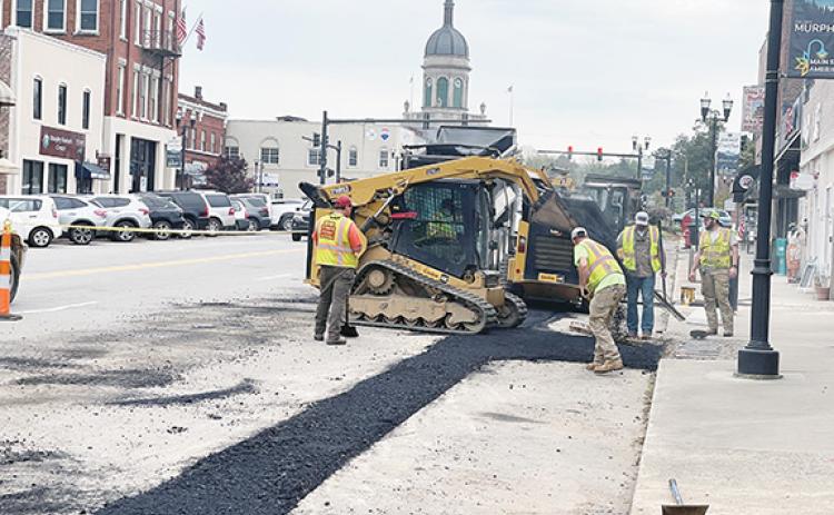 Randy Foster/editor@cherokeescout.com A road crew puts down new asphalt in downtown Murphy, where the four major streets will be repaved and meet at an intersection that will be reconfigured as a traffic circle.